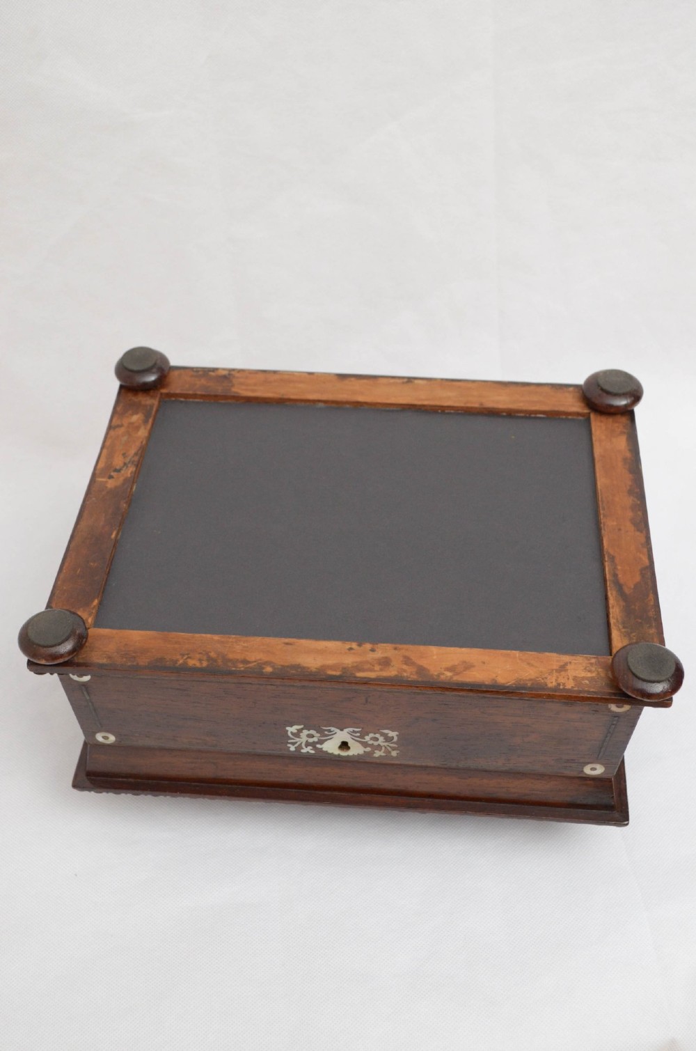 A William IV dark rosewood jewellery box featuring mother-of-pearl inlays, a tiered sarcophagus lid, carved gadrooned borders, and small bun feet. View V