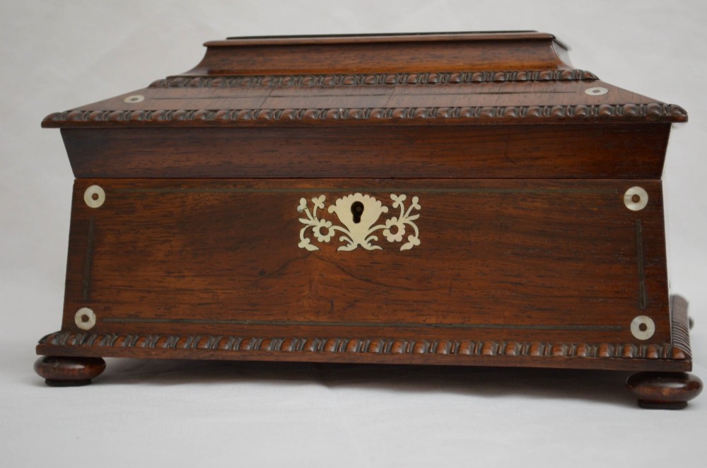 A William IV dark rosewood jewellery box featuring mother-of-pearl inlays, a tiered sarcophagus lid, carved gadrooned borders, and small bun feet. View XIII