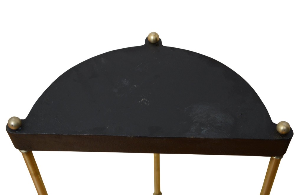 An antique brass demi-lune stick stand featuring three vertical supports, turned finials, a divided top rail, and a semi-circular black cast iron drip tray base. View II