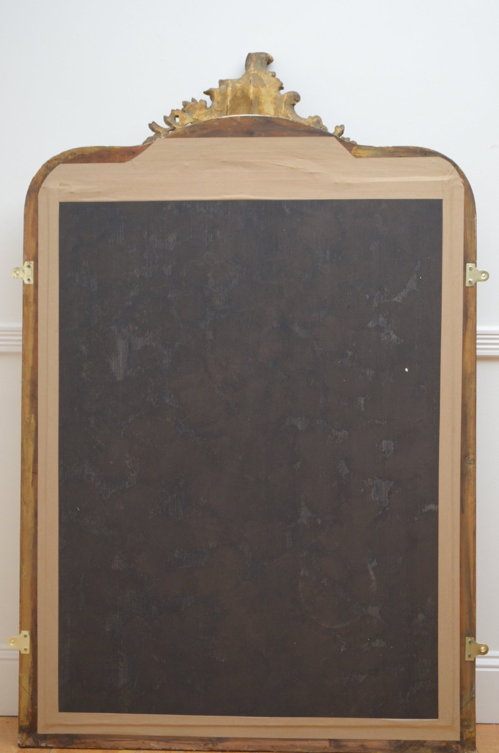 A tall 19th-century French wall mirror with a gilded gesso frame, arched top, ornate shell cresting, and mild foxing across the mirror plate. View XIII