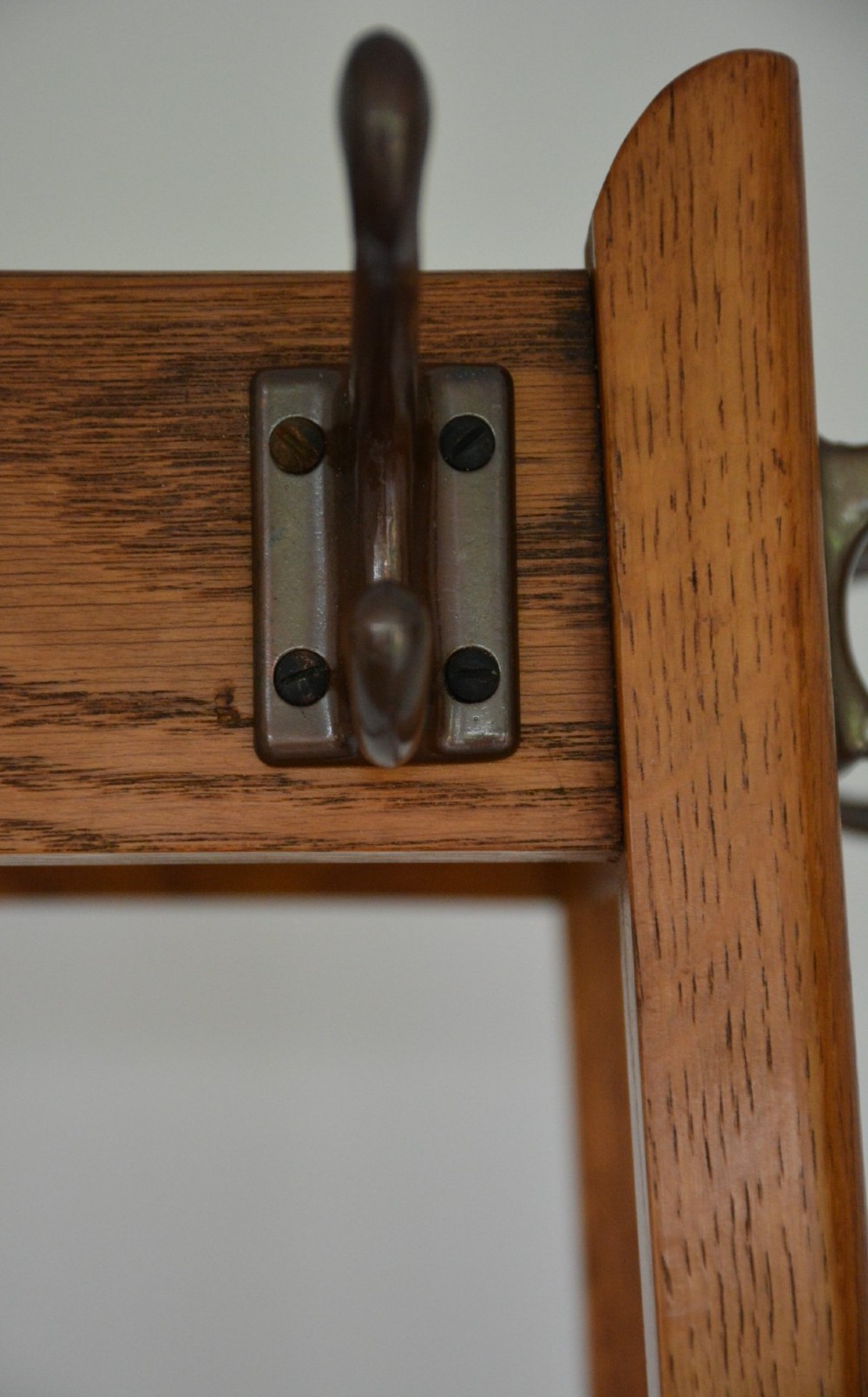 A tall tapered oak coat and umbrella stand featuring top metal hooks, an intermediate square divider, and a dark metal drip tray at the base. View VIII