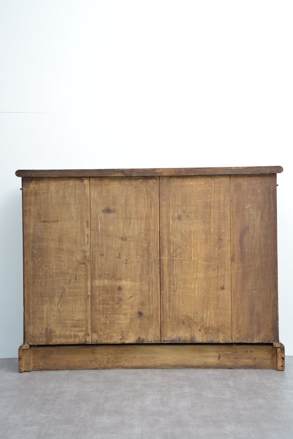 A late Victorian low solid oak open bookcase featuring three horizontal shelves, fluted pilasters, and carved corner rosettes. View II