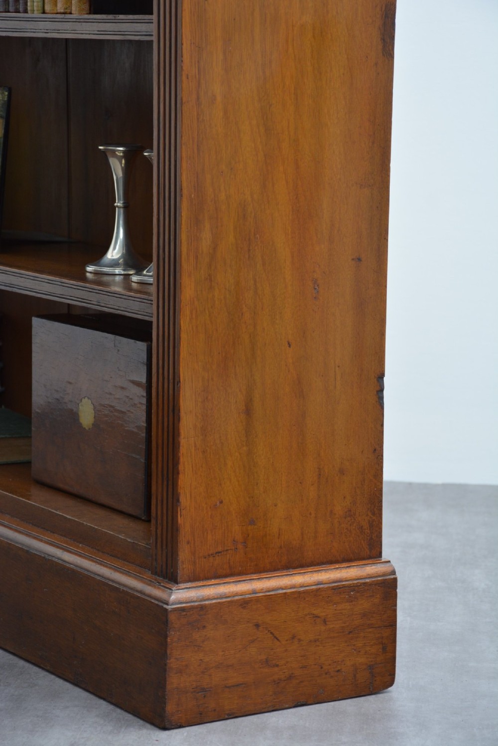 A late Victorian low solid oak open bookcase featuring three horizontal shelves, fluted pilasters, and carved corner rosettes. View XI