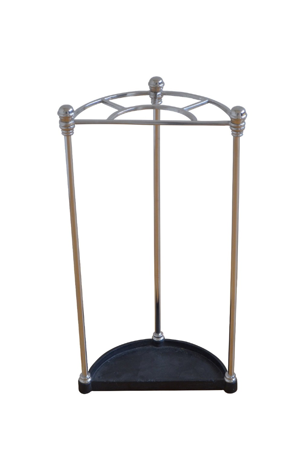 An Art Deco demi-lune nickel-plated umbrella stand featuring a semi-circular top frame with five divisions, vertical support rods with spherical finials, and a black cast iron drip tray base. View II
