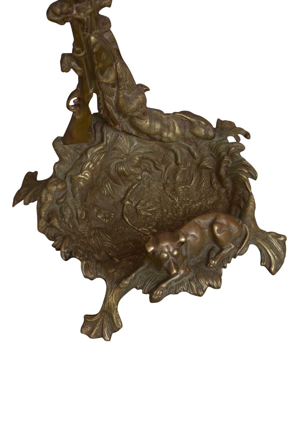 A cast brass stick stand featuring relief motifs of a resting hunting dog, crossed rifles, and foliage with a drip pan base. View IX