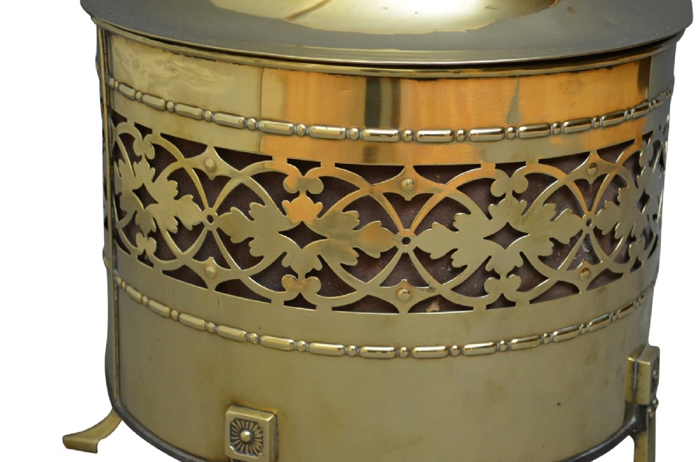 A cylindrical Edwardian polished brass coal bucket featuring a fretwork band, domed lid with finial, and three cast fluted feet. View VI