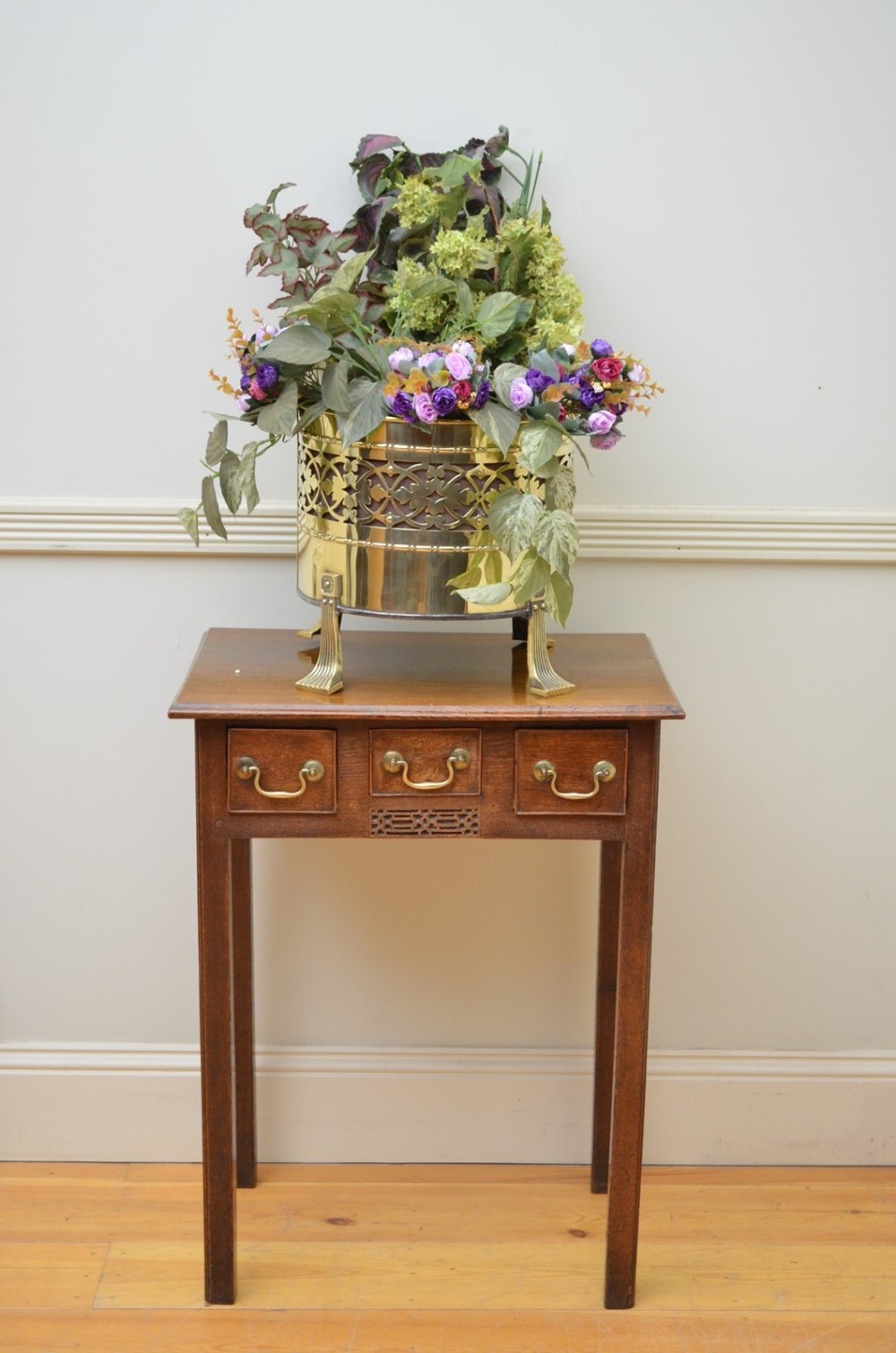 A cylindrical Edwardian polished brass coal bucket featuring a fretwork band, domed lid with finial, and three cast fluted feet. View IX