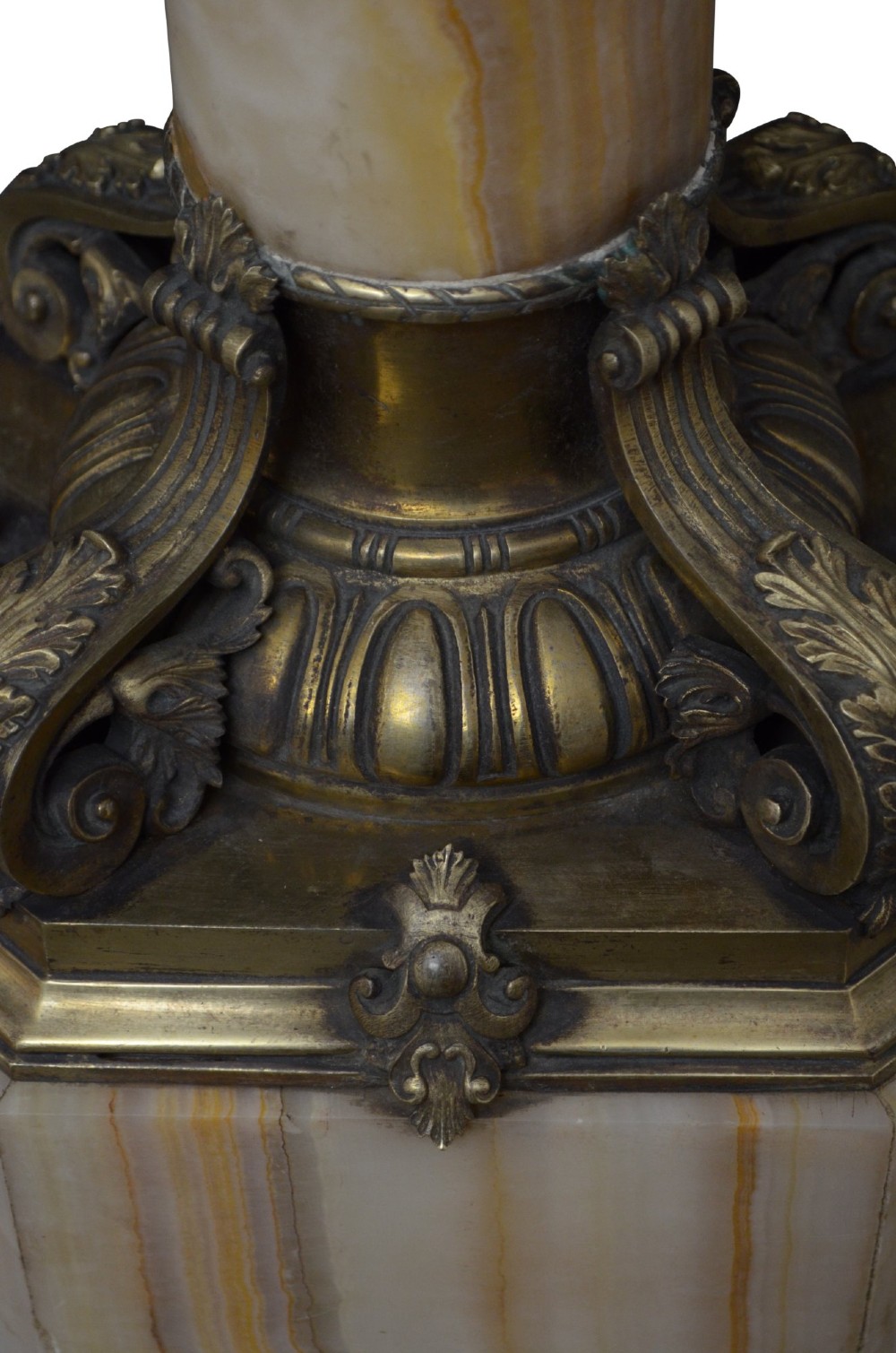 A tall cylindrical cream and amber onyx column featuring gilt bronze ormolu mounts at the top and base, set on a square plinth. View IX