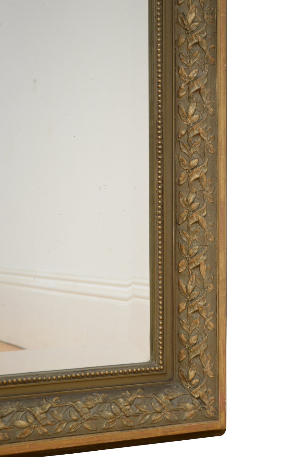 A large rectangular French wall mirror featuring a gilded wood frame, an olive green painted frieze decorated with carved floral swags, and an ornate ribbon bow crest. View VIII