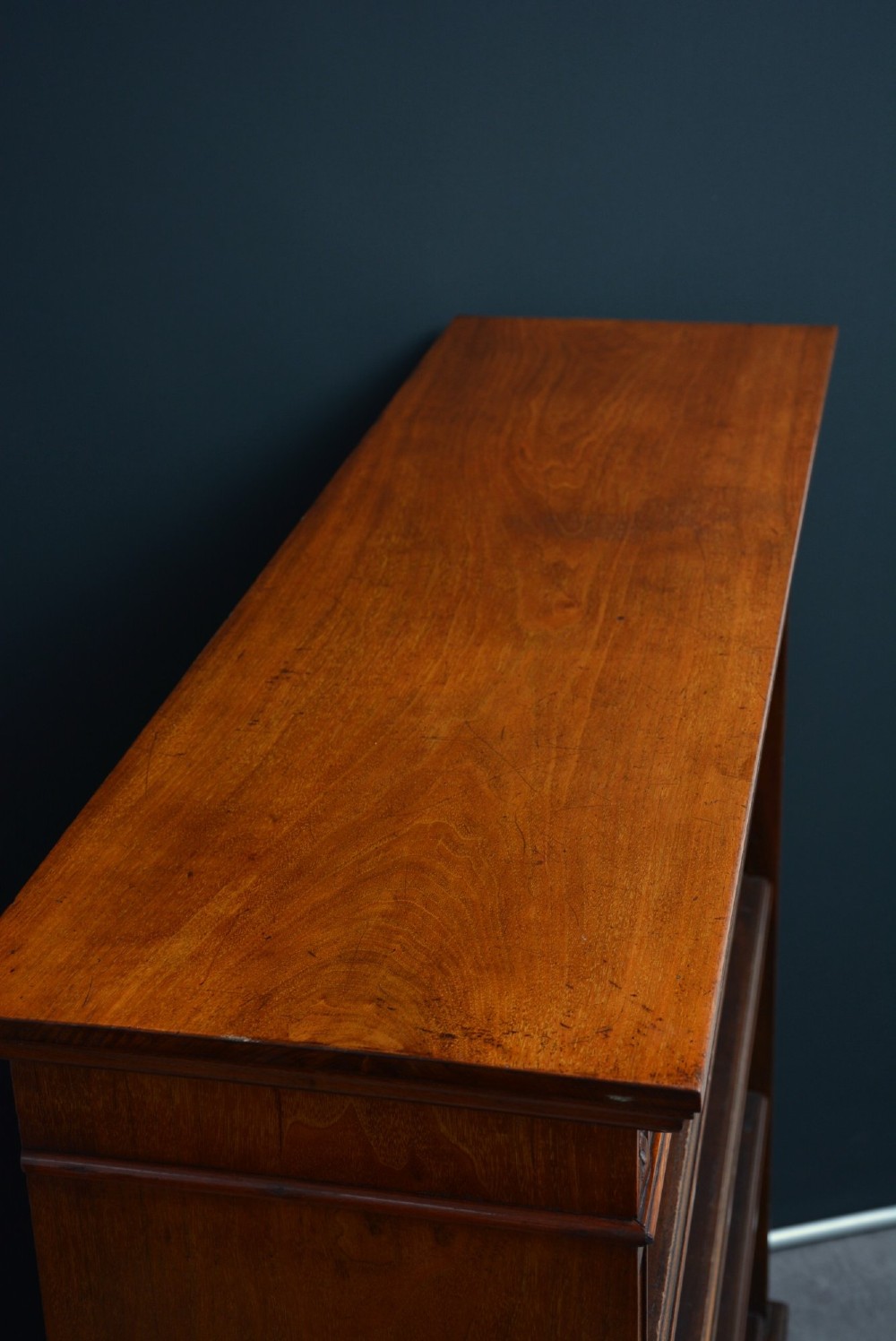 A late Victorian open walnut bookcase featuring a carved rosette frieze, moulded top cornice, adjustable shelves, and a solid plinth base. View IV
