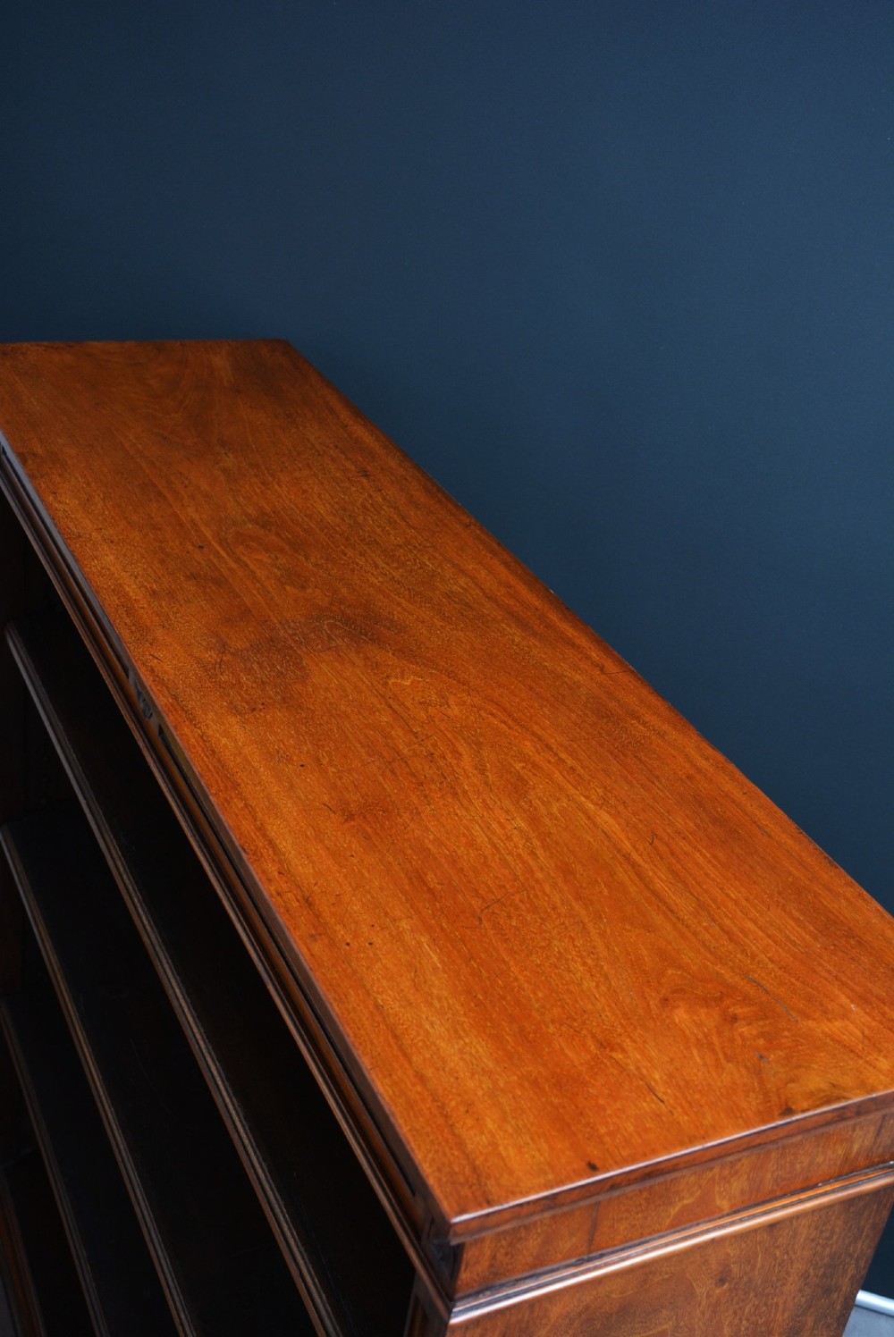 A late Victorian open walnut bookcase featuring a carved rosette frieze, moulded top cornice, adjustable shelves, and a solid plinth base. View V