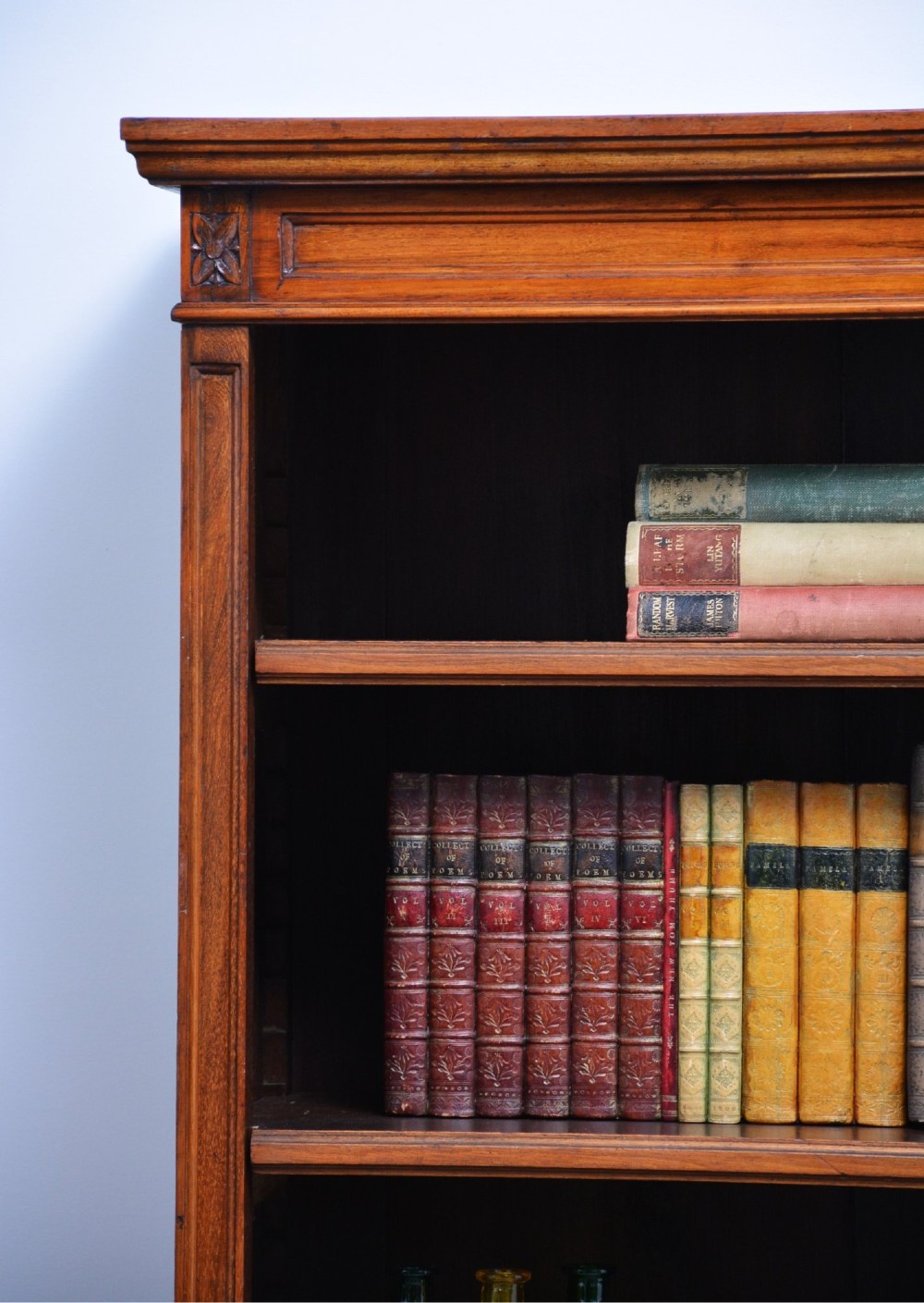 A late Victorian open walnut bookcase featuring a carved rosette frieze, moulded top cornice, adjustable shelves, and a solid plinth base. View VIII