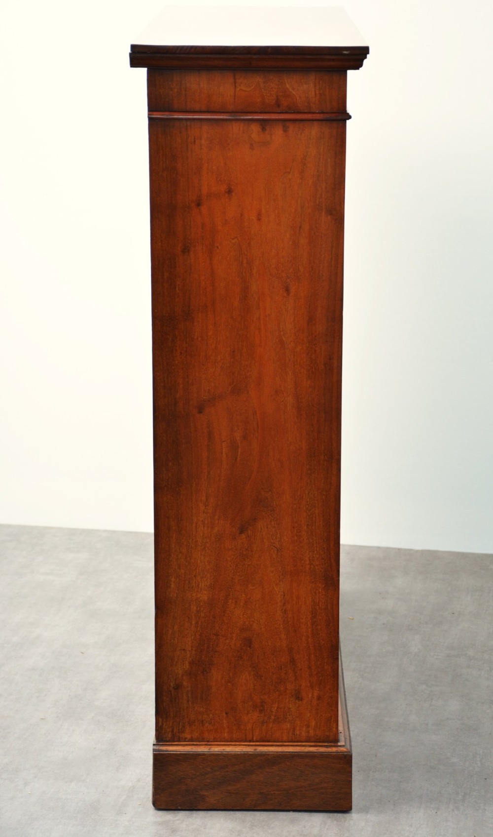 A late Victorian open walnut bookcase featuring a carved rosette frieze, moulded top cornice, adjustable shelves, and a solid plinth base. View XIII