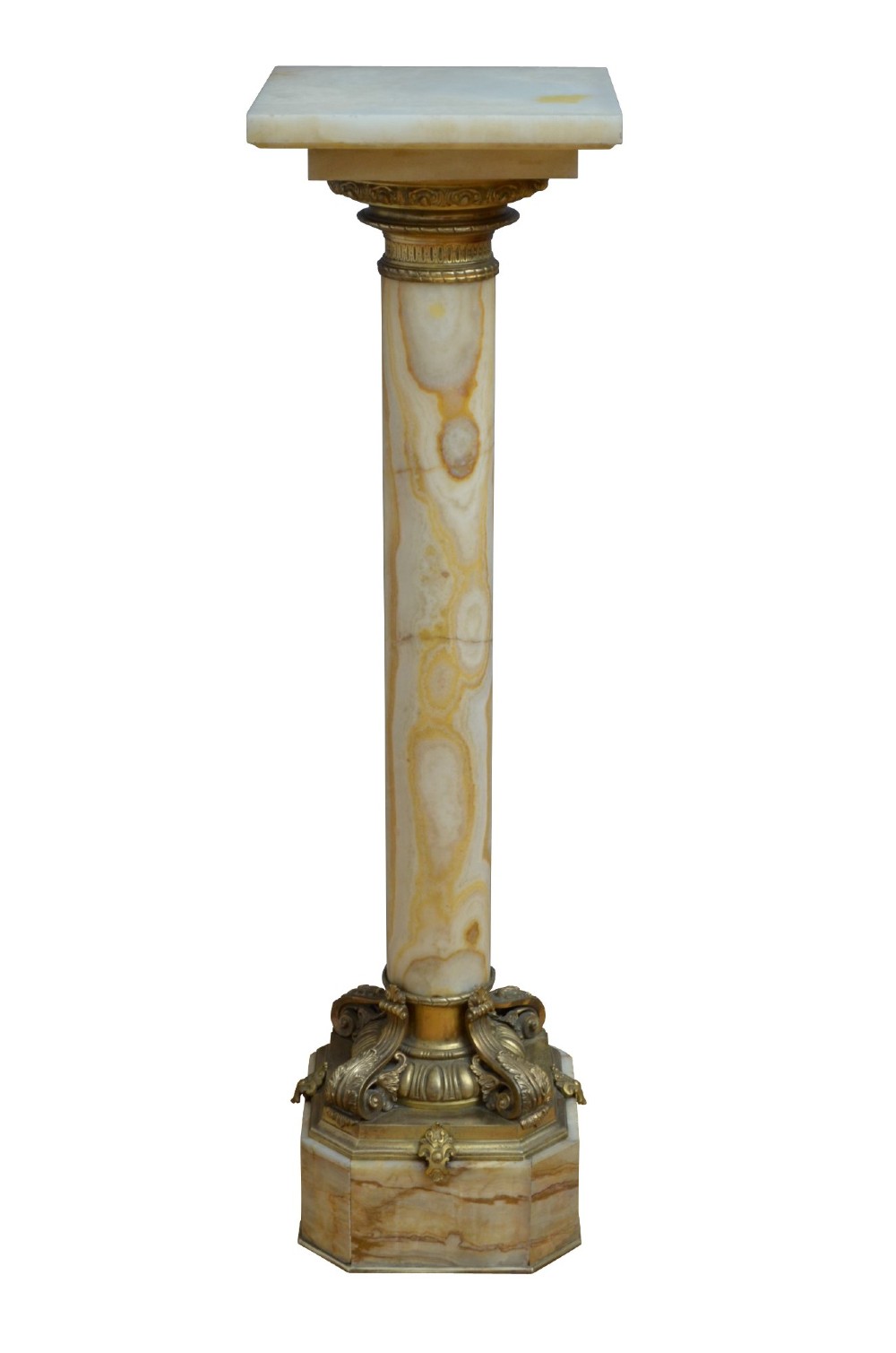 A pair of tall cylindrical onyx marble pedestals with square top plinths and ornate gilt ormolu collars and bases. View IV