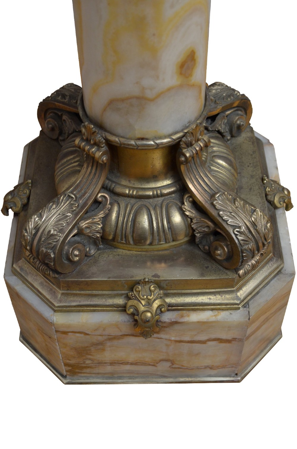 A pair of tall cylindrical onyx marble pedestals with square top plinths and ornate gilt ormolu collars and bases. View IX