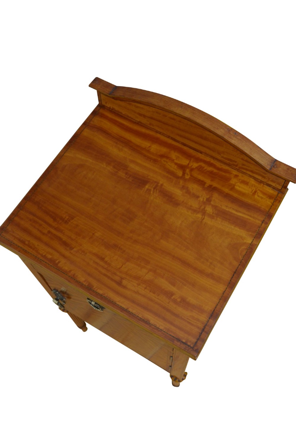 An antique satinwood bedside cupboard featuring a shaped gallery back, top drawer, chevron parquetry cupboard door, and slender fluted legs. View V