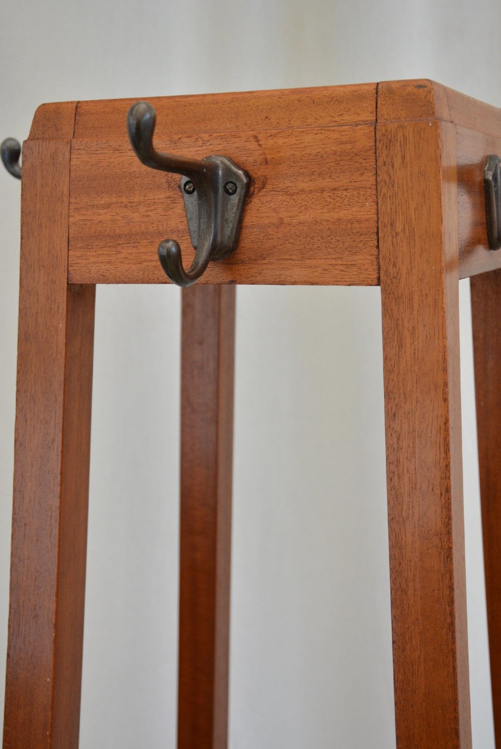 A tall tapered solid mahogany hall coat stand featuring top metal hooks, an umbrella divider section, and a dark metal drip tray base. View VIII