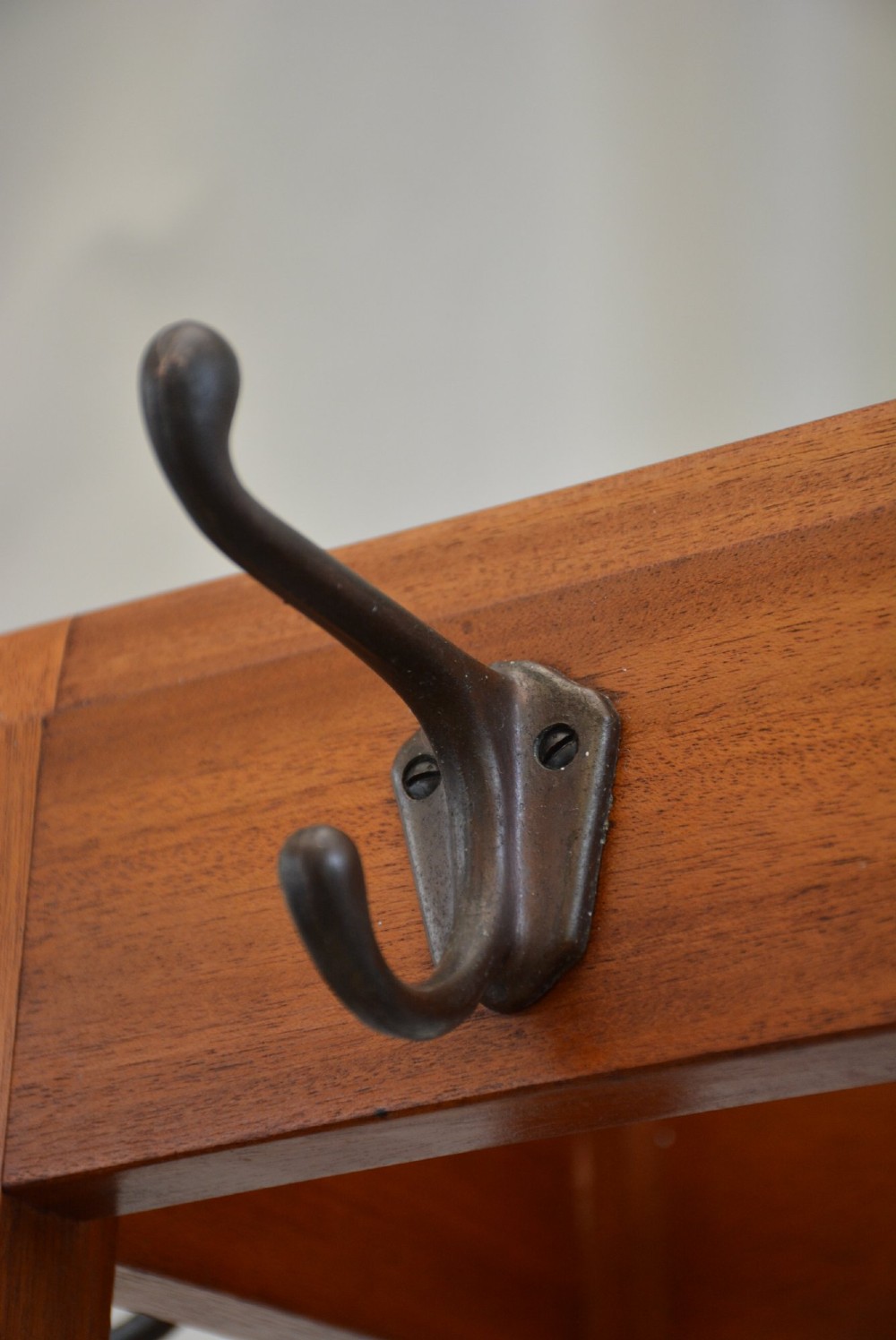A tall tapered solid mahogany hall coat stand featuring top metal hooks, an umbrella divider section, and a dark metal drip tray base. View X