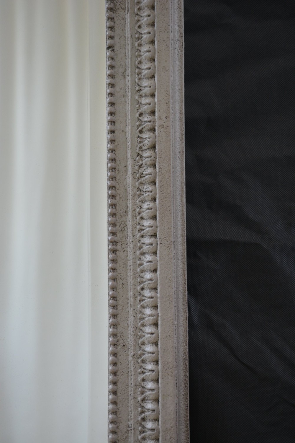 A light grey painted arched mirror featuring a carved ribbon bow crest and acanthus scroll corner details. View V