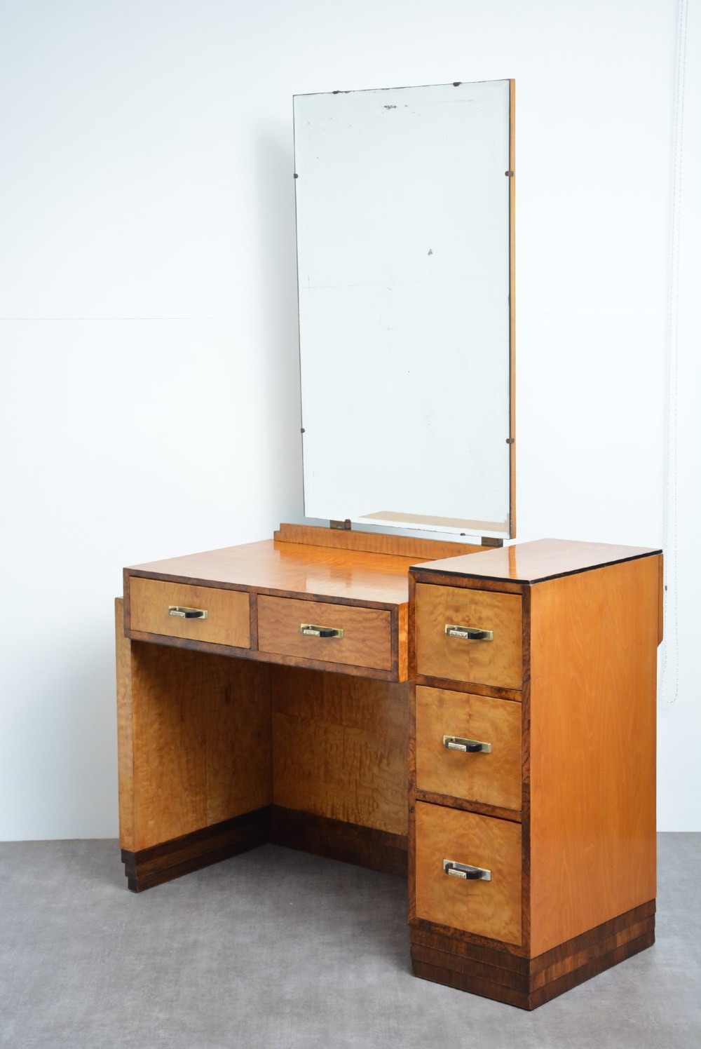An Art Deco asymmetrical dressing table crafted in burr maple veneer with an offset pedestal of drawers and a large frameless mirror. View III