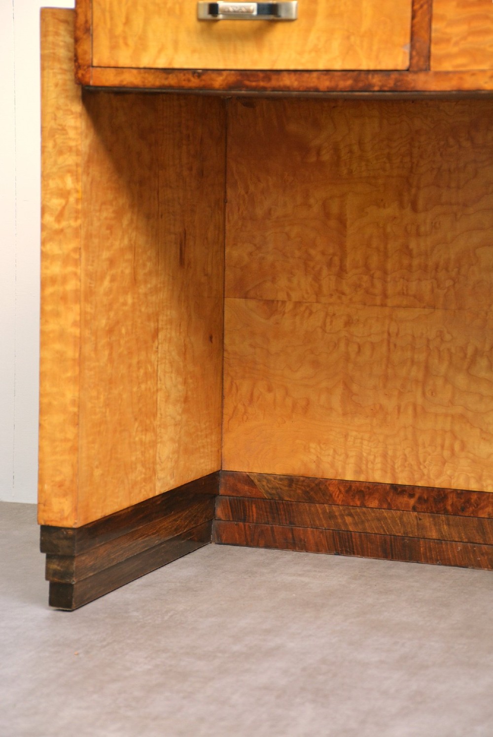 An Art Deco asymmetrical dressing table crafted in burr maple veneer with an offset pedestal of drawers and a large frameless mirror. View XIII