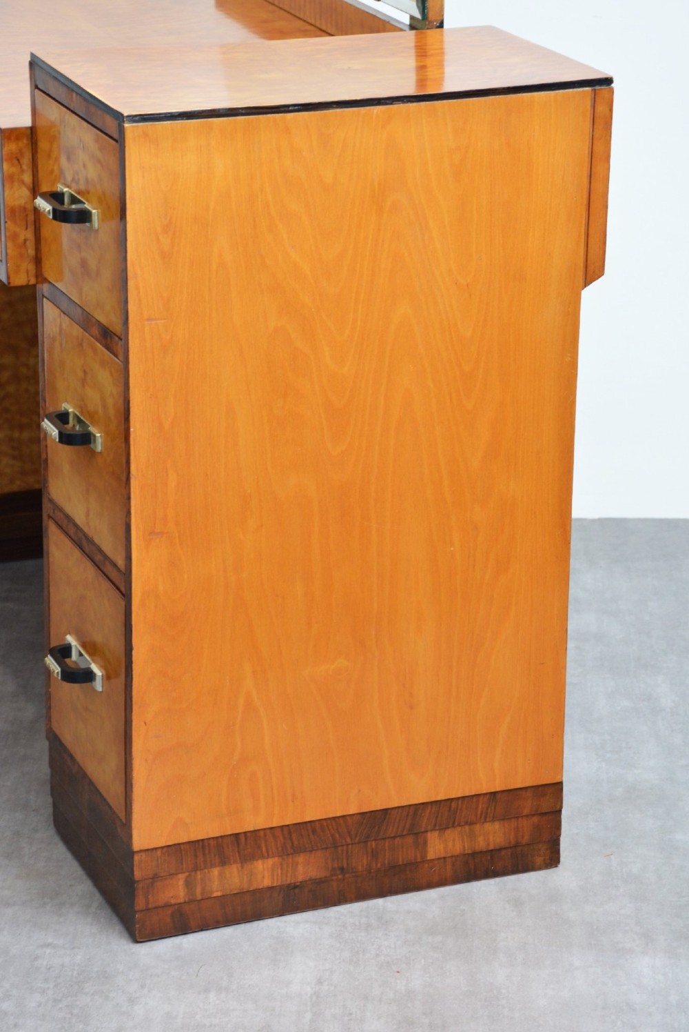 An Art Deco asymmetrical dressing table crafted in burr maple veneer with an offset pedestal of drawers and a large frameless mirror. View XV