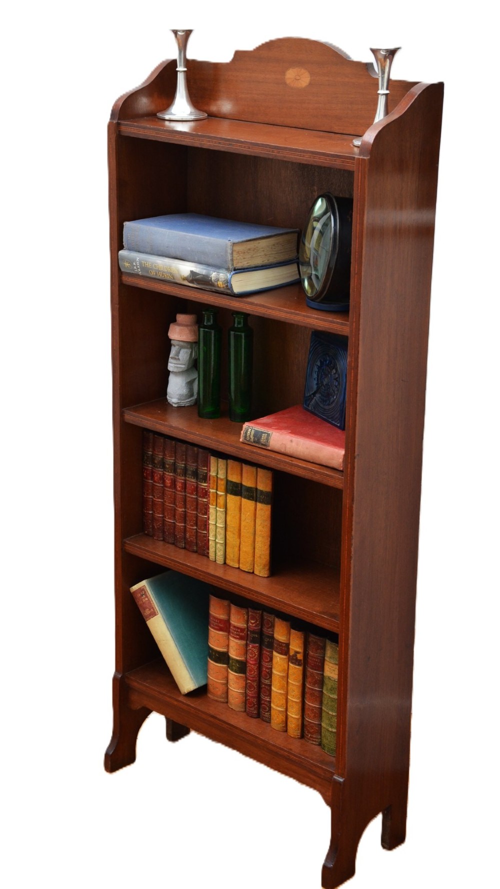 A slim Edwardian open mahogany bookcase featuring four fixed shelves, a shaped top gallery with a central oval inlay, and bracket feet. View XII