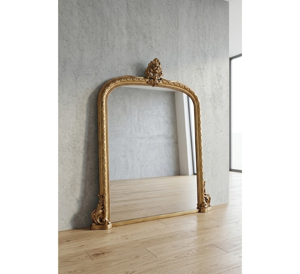 A large arched giltwood overmantel mirror featuring an ornate acanthus crest top and decorative side spandrels.