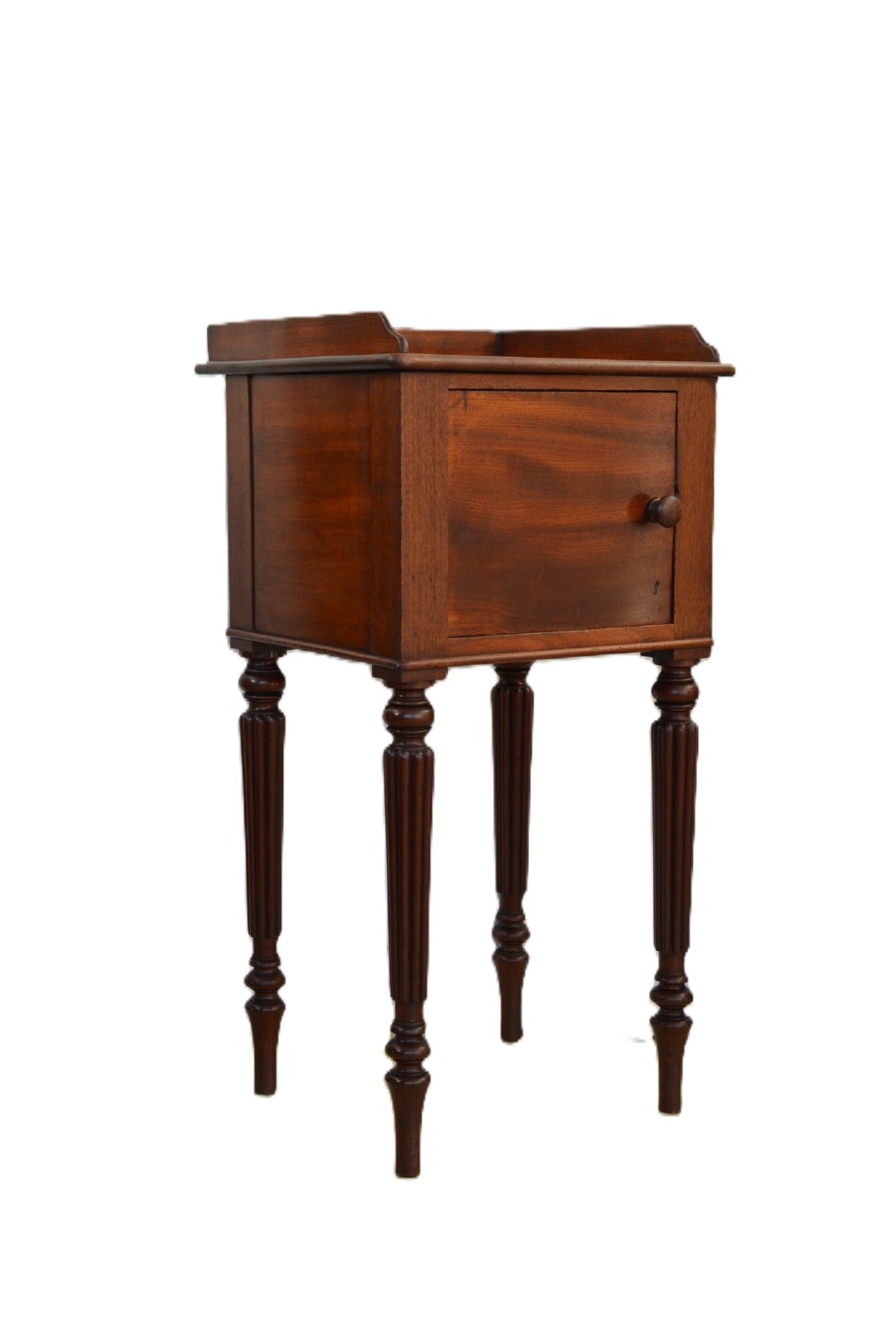 A William IV mahogany nightstand featuring a gallery top, a single door cupboard with a turned wooden knob, and four slender reeded tapering legs. View V