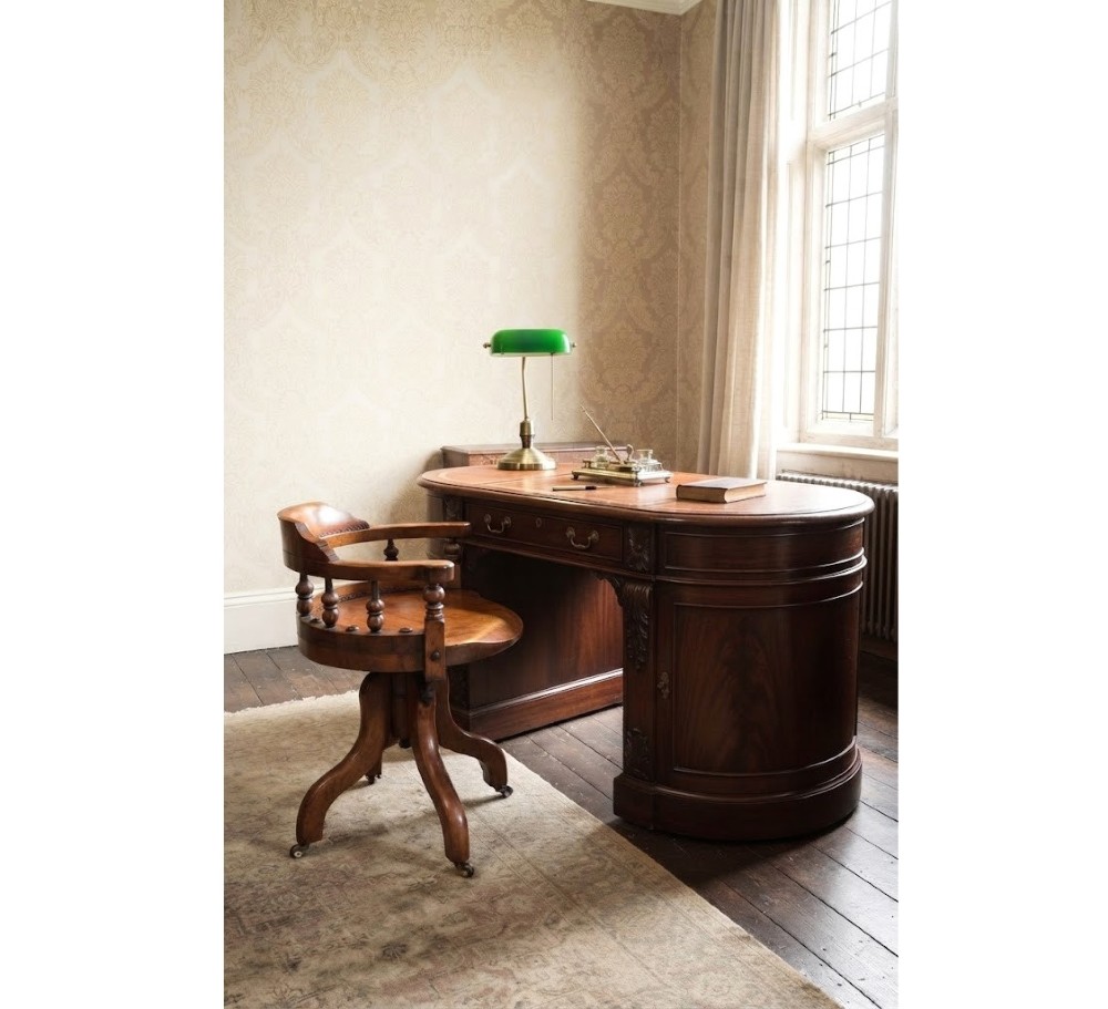 A 19th-century Victorian walnut revolving desk chair featuring a curved backrest with turned spindles, a contoured solid seat, and splayed legs on castors. View XIV
