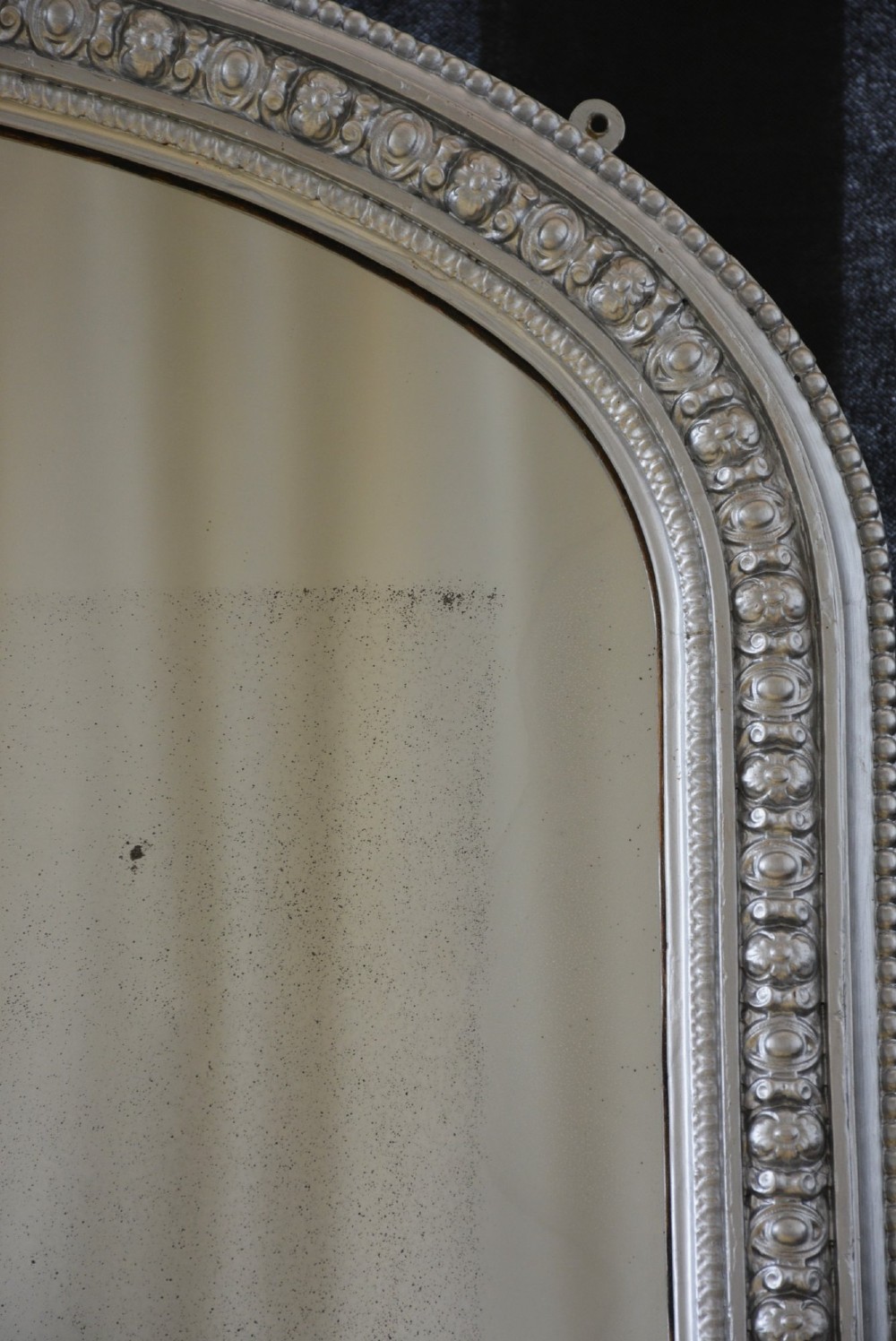 An arched antique French silver gilt overmantel mirror featuring a moulded frame with subtle beaded detailing and rounded upper corners. View VI