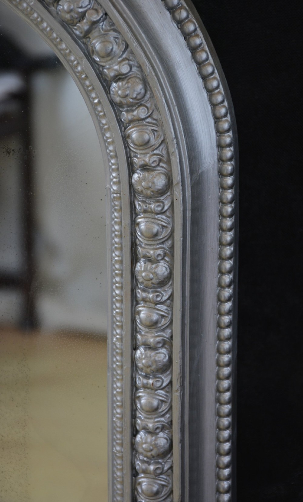 An arched antique French silver gilt overmantel mirror featuring a moulded frame with subtle beaded detailing and rounded upper corners. View IX
