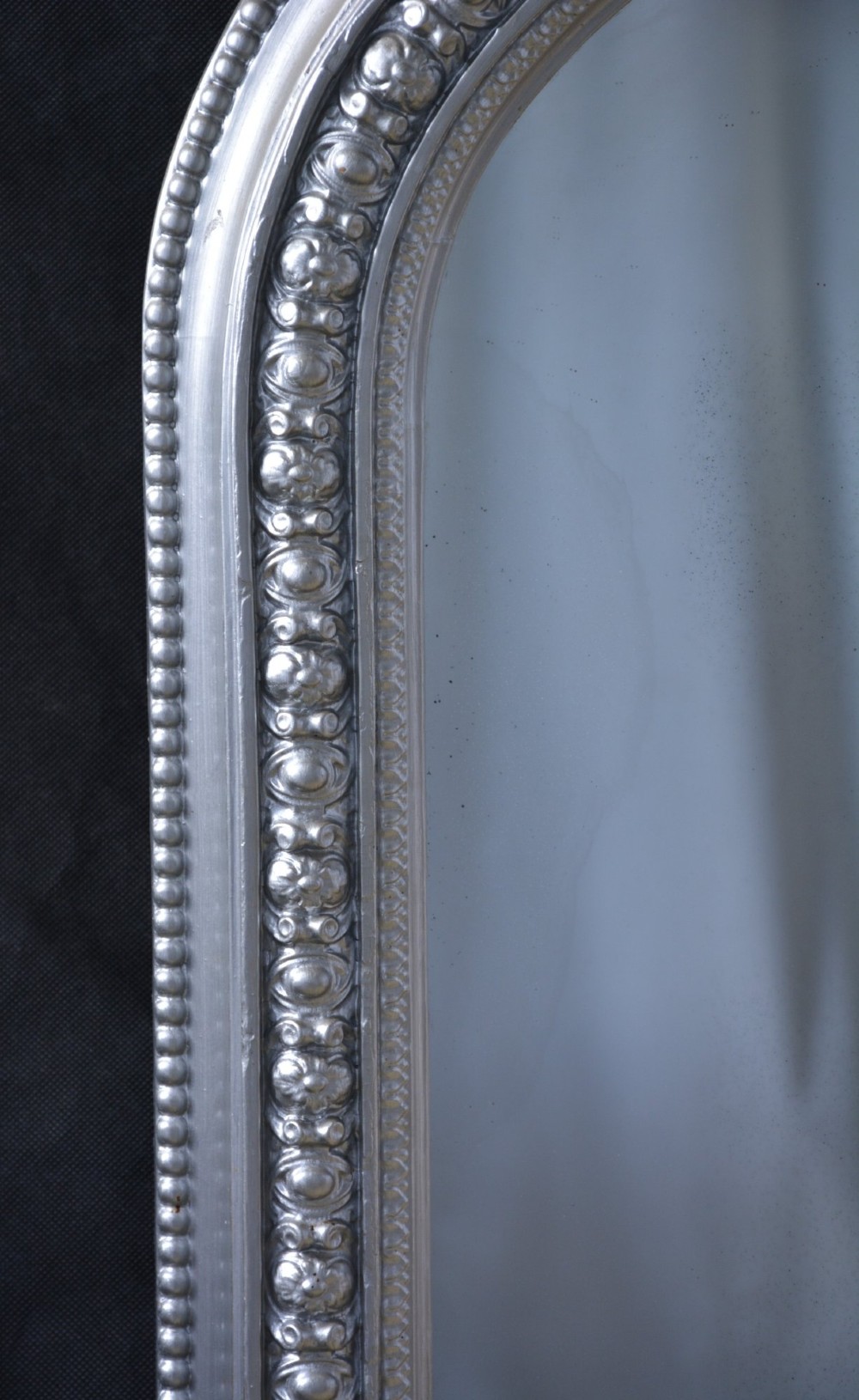 An arched antique French silver gilt overmantel mirror featuring a moulded frame with subtle beaded detailing and rounded upper corners. View XII