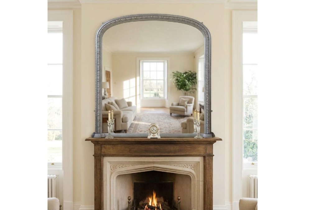 An arched antique French silver gilt overmantel mirror featuring a moulded frame with subtle beaded detailing and rounded upper corners.