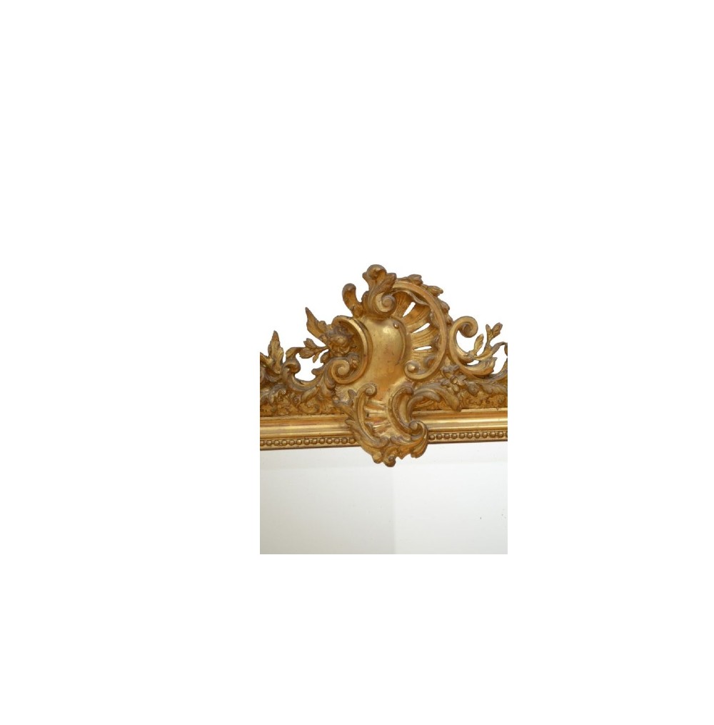 A tall French giltwood wall mirror featuring a carved foliate crest and a moulded gold frame. View VI