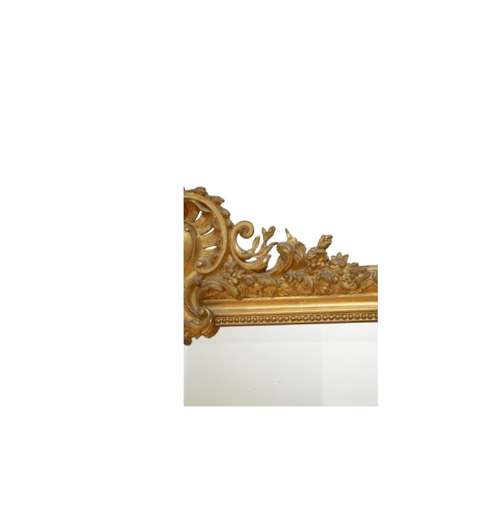 A tall French giltwood wall mirror featuring a carved foliate crest and a moulded gold frame. View VII