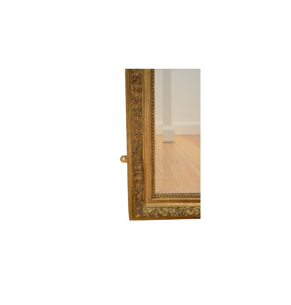 A tall French giltwood wall mirror featuring a carved foliate crest and a moulded gold frame. View XII