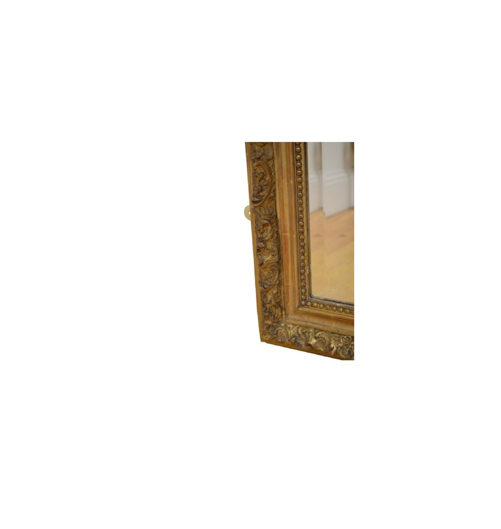 A tall French giltwood wall mirror featuring a carved foliate crest and a moulded gold frame. View XV