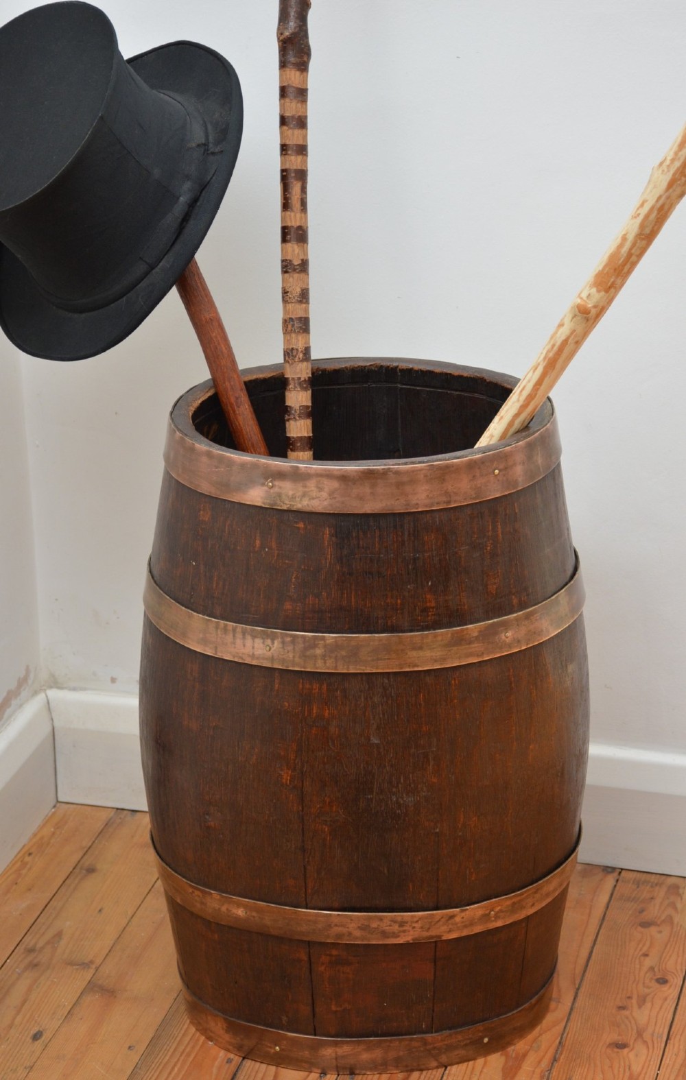 A dark oak coopered barrel umbrella stand with copper binding straps and metal rivets. View II