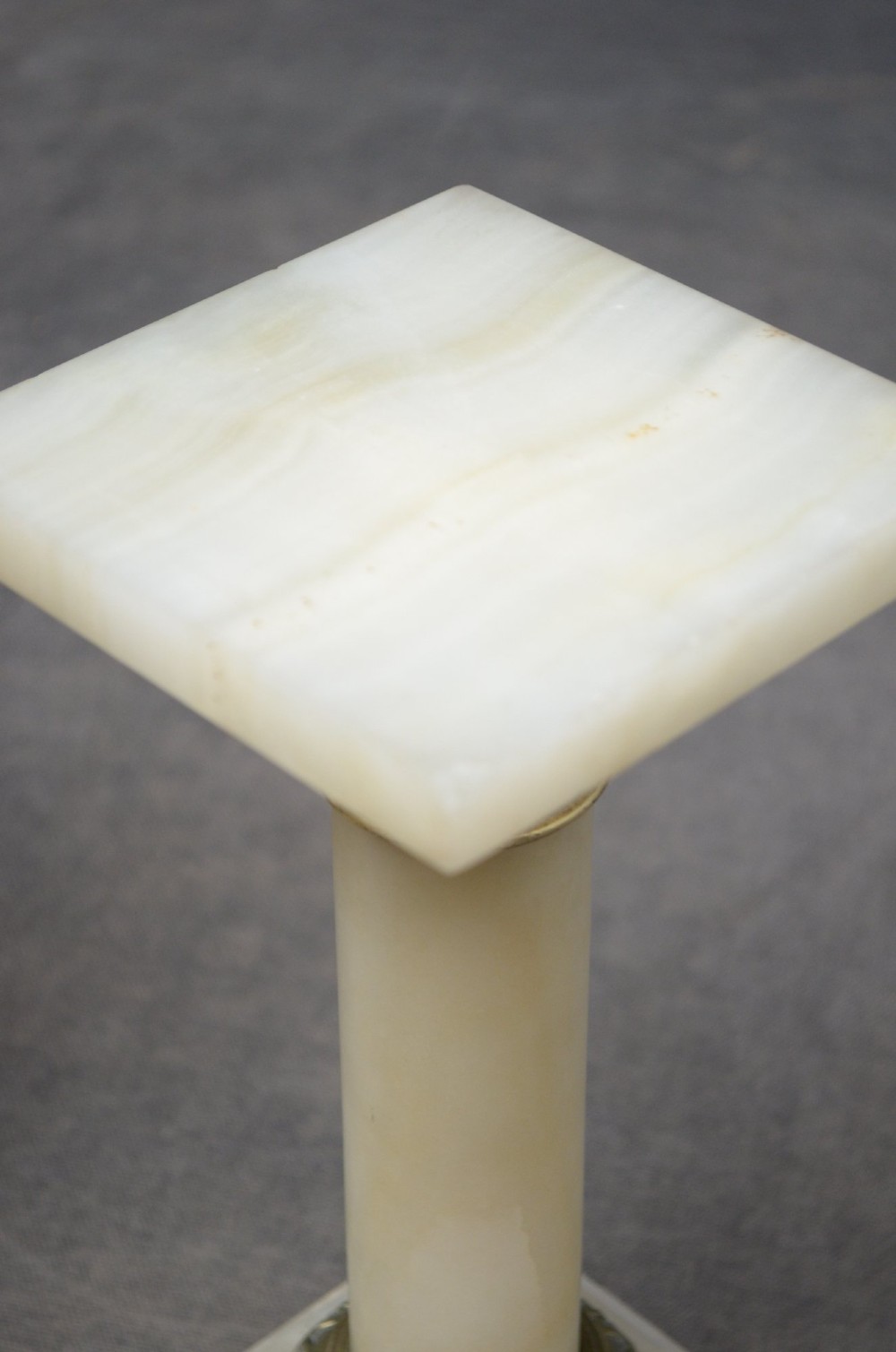 A pair of low Victorian cream onyx columns featuring ornate brass ormolu capitals and square tiered bases. View VIII