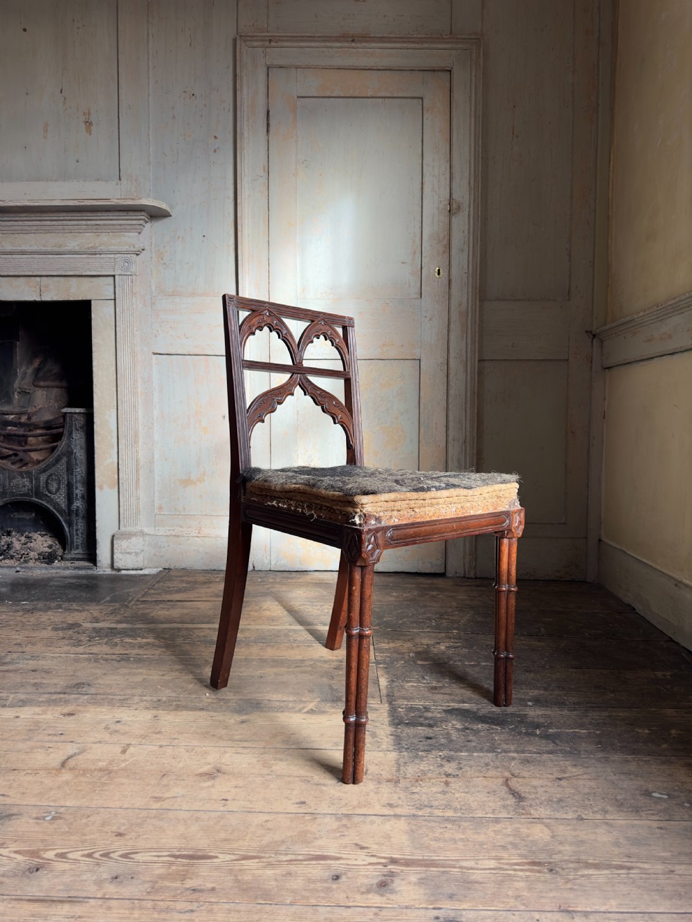 An antique Georgian mahogany side chair featuring carved Gothic tracery in the backrest and turned legs. View II