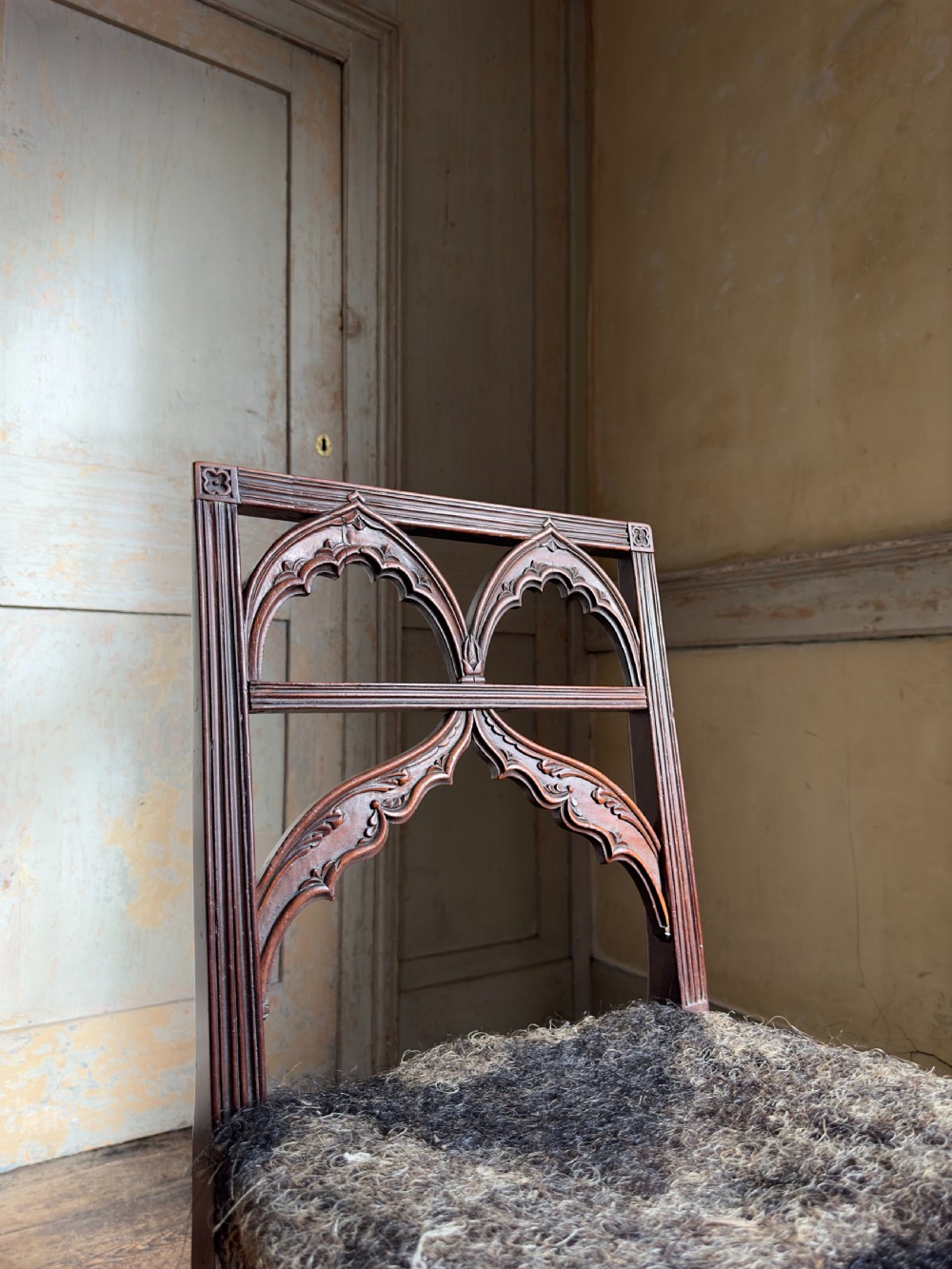 An antique Georgian mahogany side chair featuring carved Gothic tracery in the backrest and turned legs. View V