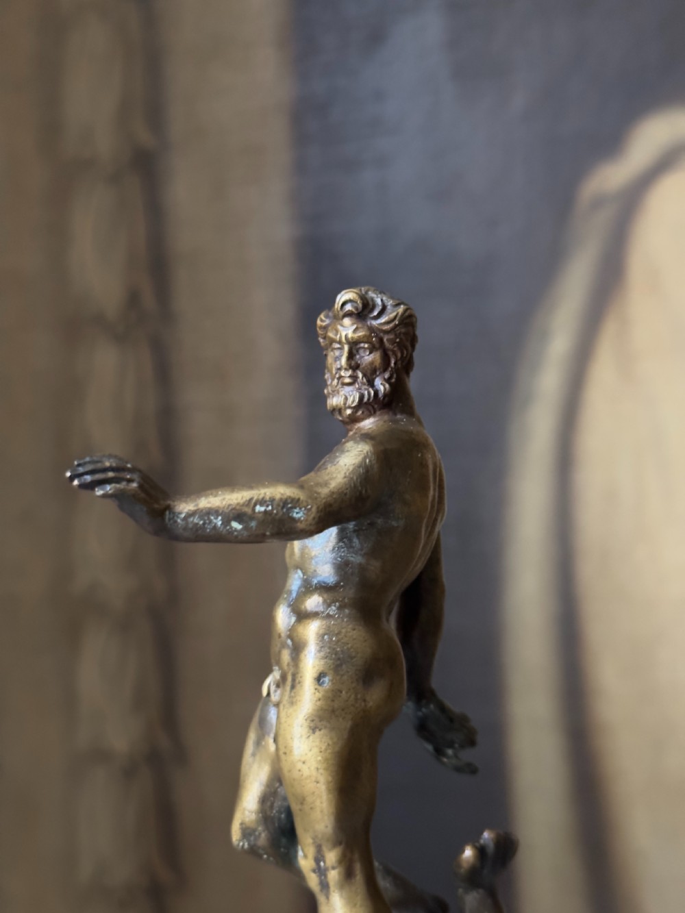 An 18th-century bronze statuette depicting the classical figure Neptune standing in contrapposto on a detailed pedestal and dark marble base. View III