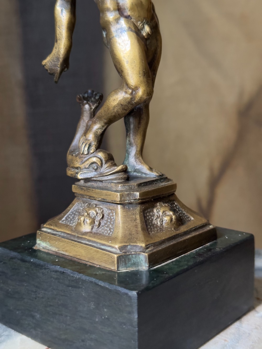 An 18th-century bronze statuette depicting the classical figure Neptune standing in contrapposto on a detailed pedestal and dark marble base. View IV