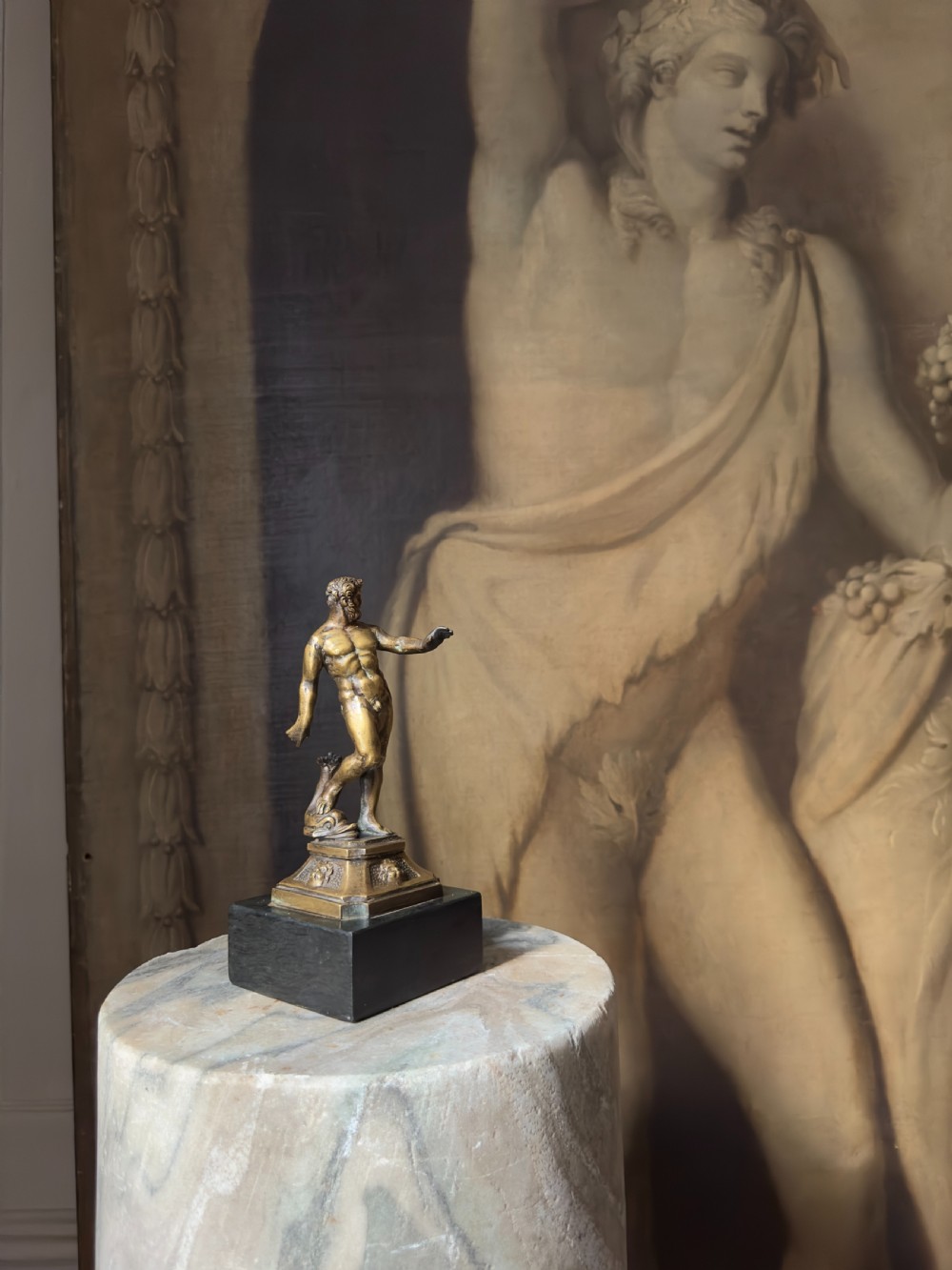 An 18th-century bronze statuette depicting the classical figure Neptune standing in contrapposto on a detailed pedestal and dark marble base. View V