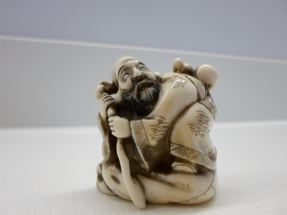 JAPANESE SIGNED IVORY NETSUKE OF AN ELDER 