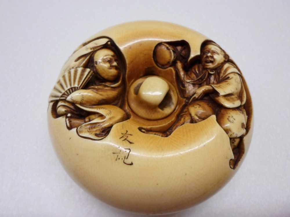 AN OVERSIZED JAPANESE IVORY MANJU NETSUKE SIGNED TOMOCHIKA View II
