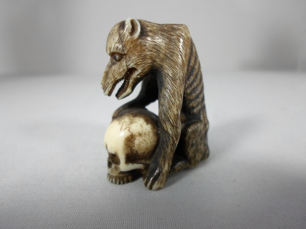 FINE AND UNUSUAL JAPANESE IVORY NETSUKE WOLF AND SKULL View II
