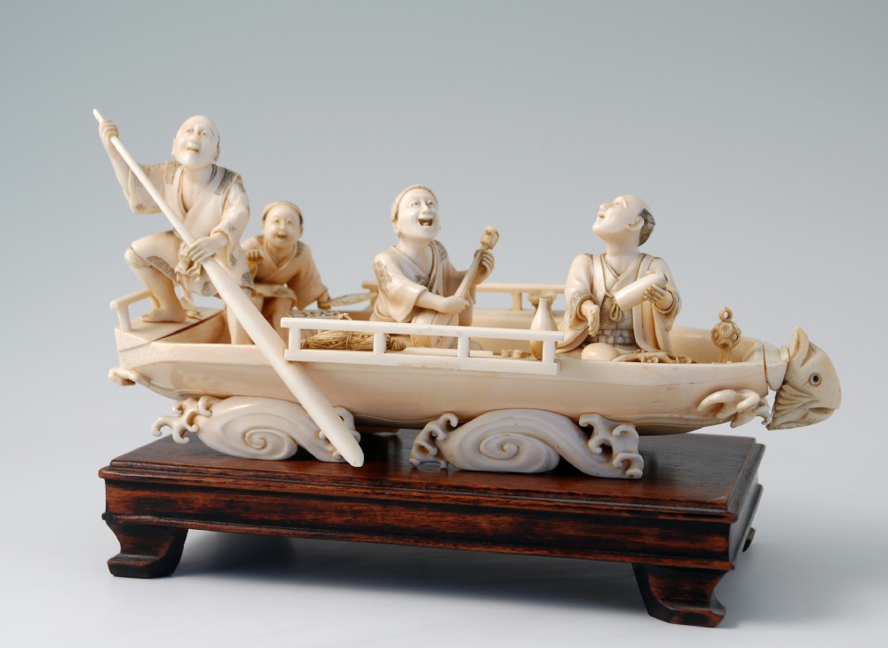 A HUMEROUS JAPANESE IVORY OKIMONO PLEASURE BOAT SIGNED 