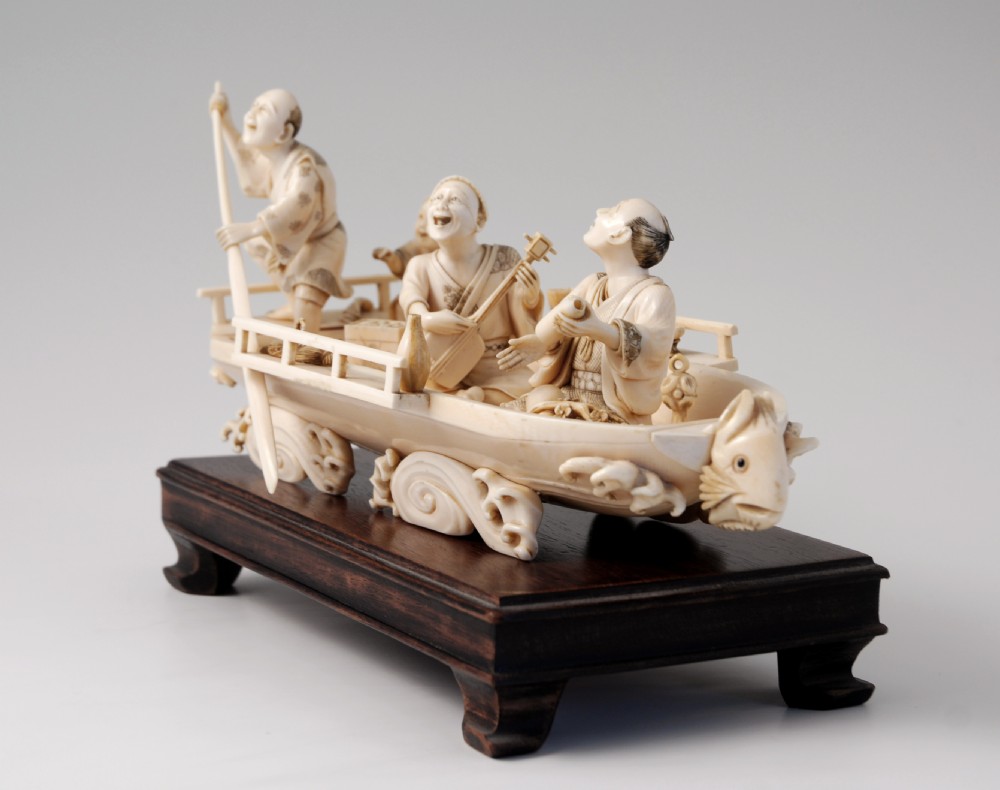 A HUMEROUS JAPANESE IVORY OKIMONO PLEASURE BOAT SIGNED 